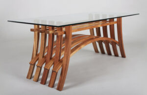 Modern curved wooden table base with a glass top